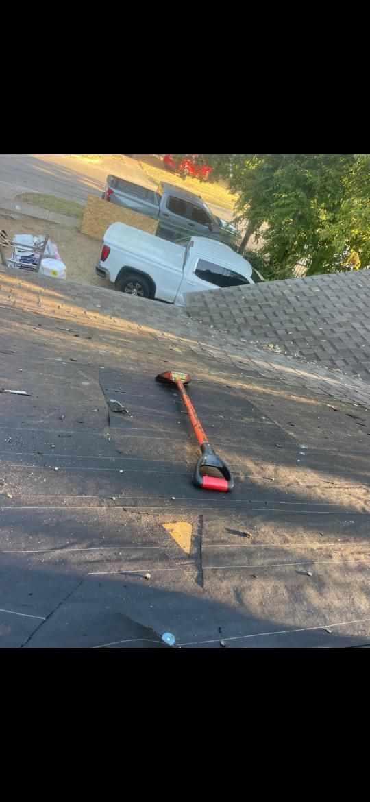 A white pickup truck stuck on a hill next to a road, with a road broom in the foreground.