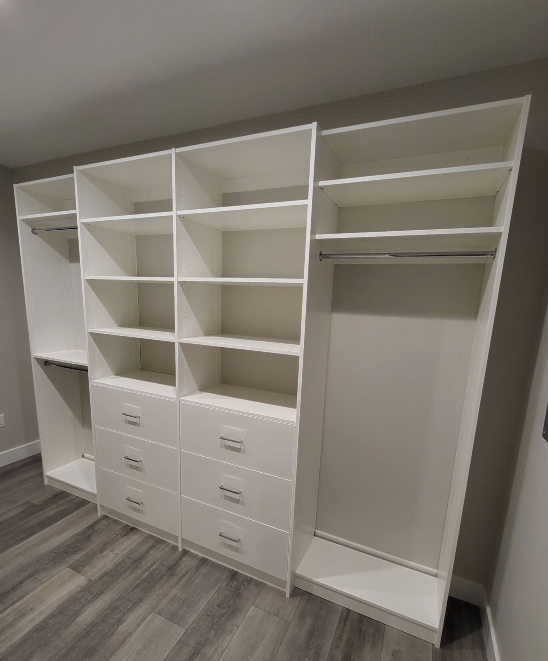 A walk in closet with lots of shelves and drawers.