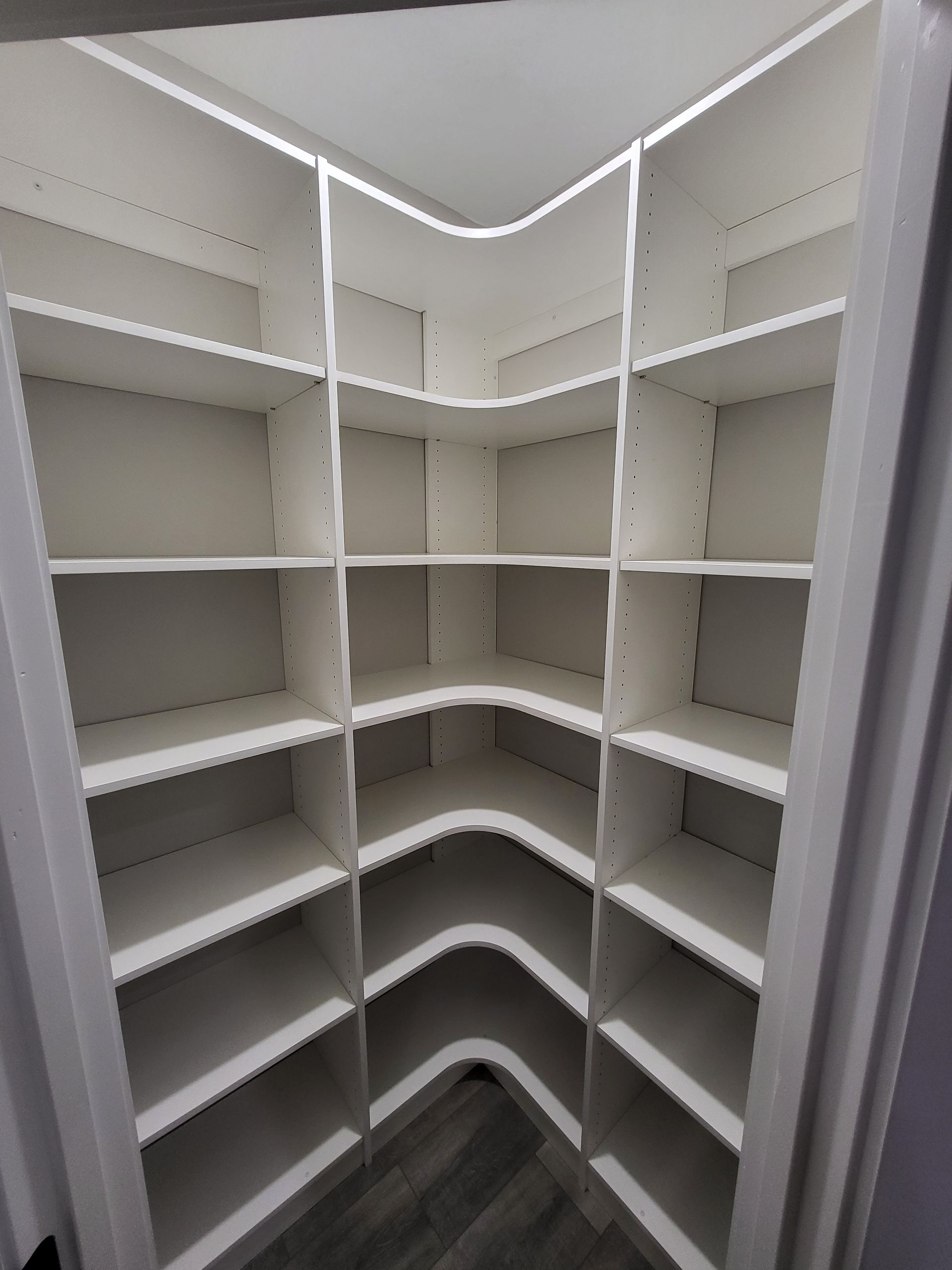 A corner of a closet with lots of shelves