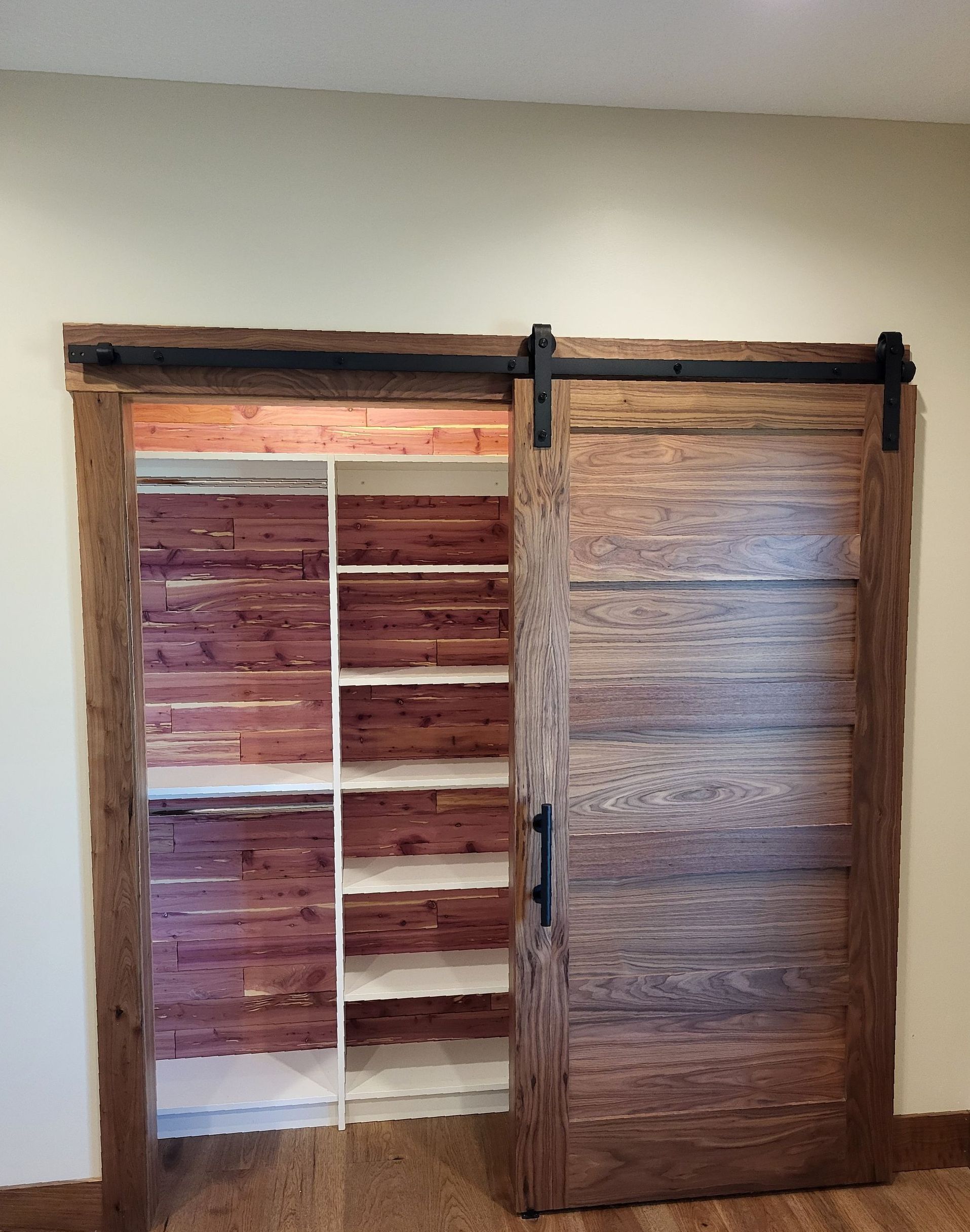 A closet with wooden shelves and sliding barn doors