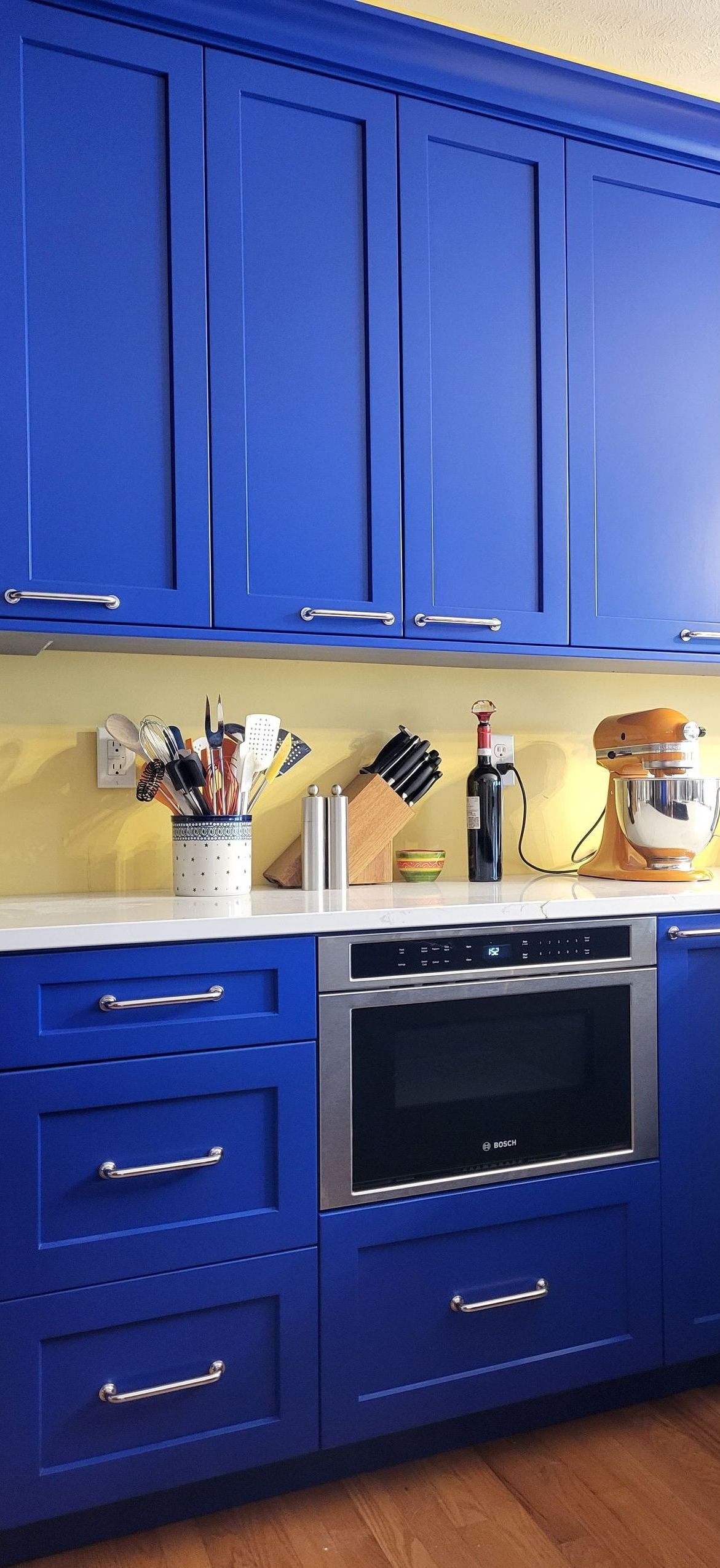 A kitchen with blue cabinets and stainless steel appliances.