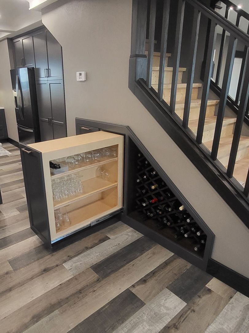 There is a wine rack under the stairs in the kitchen.