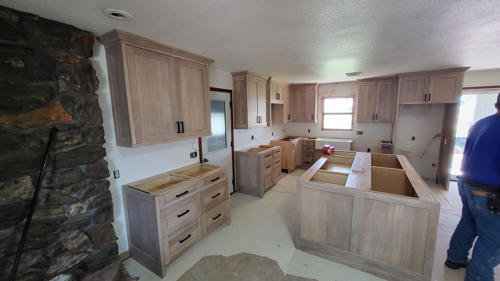 A man is standing in a kitchen that is being remodeled.