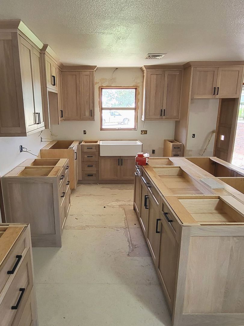 A kitchen under construction with wooden cabinets and a sink.