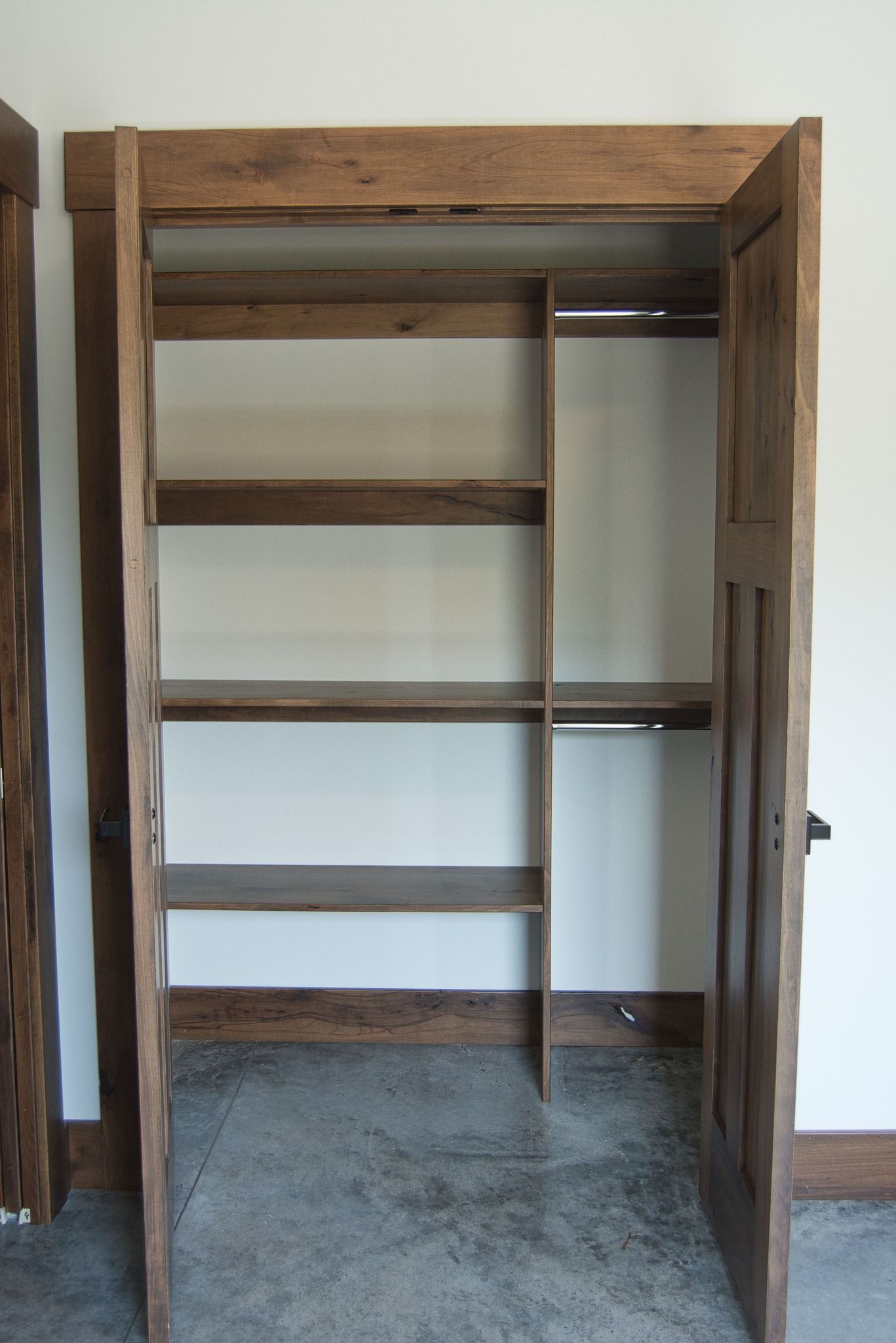 A closet with wooden shelves and a concrete floor