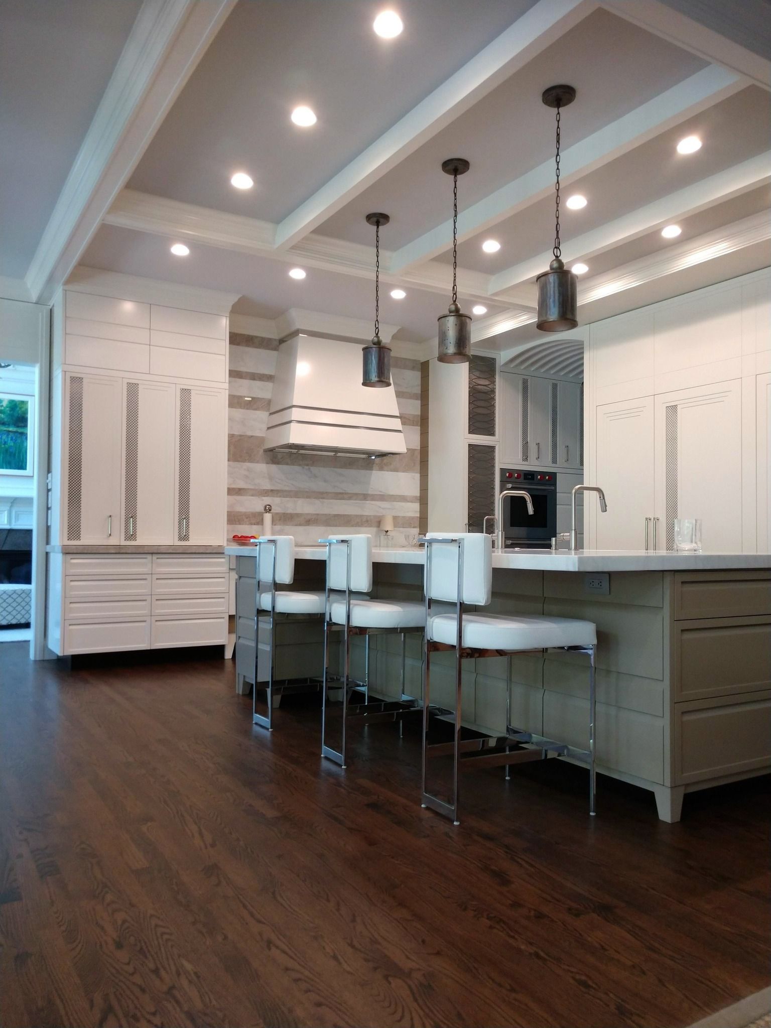 A kitchen with white cabinets and a large island