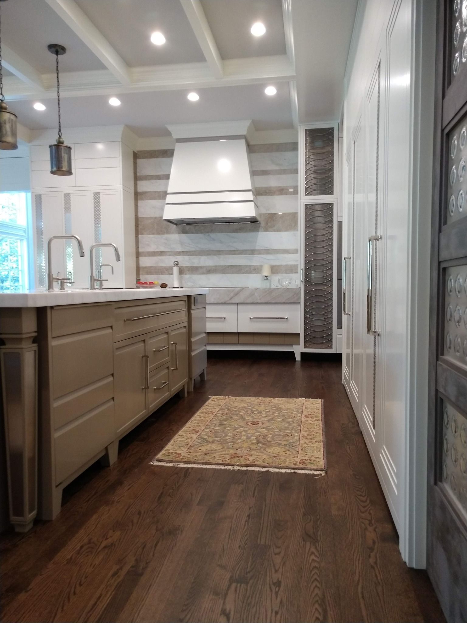A kitchen with a large island and a rug on the floor