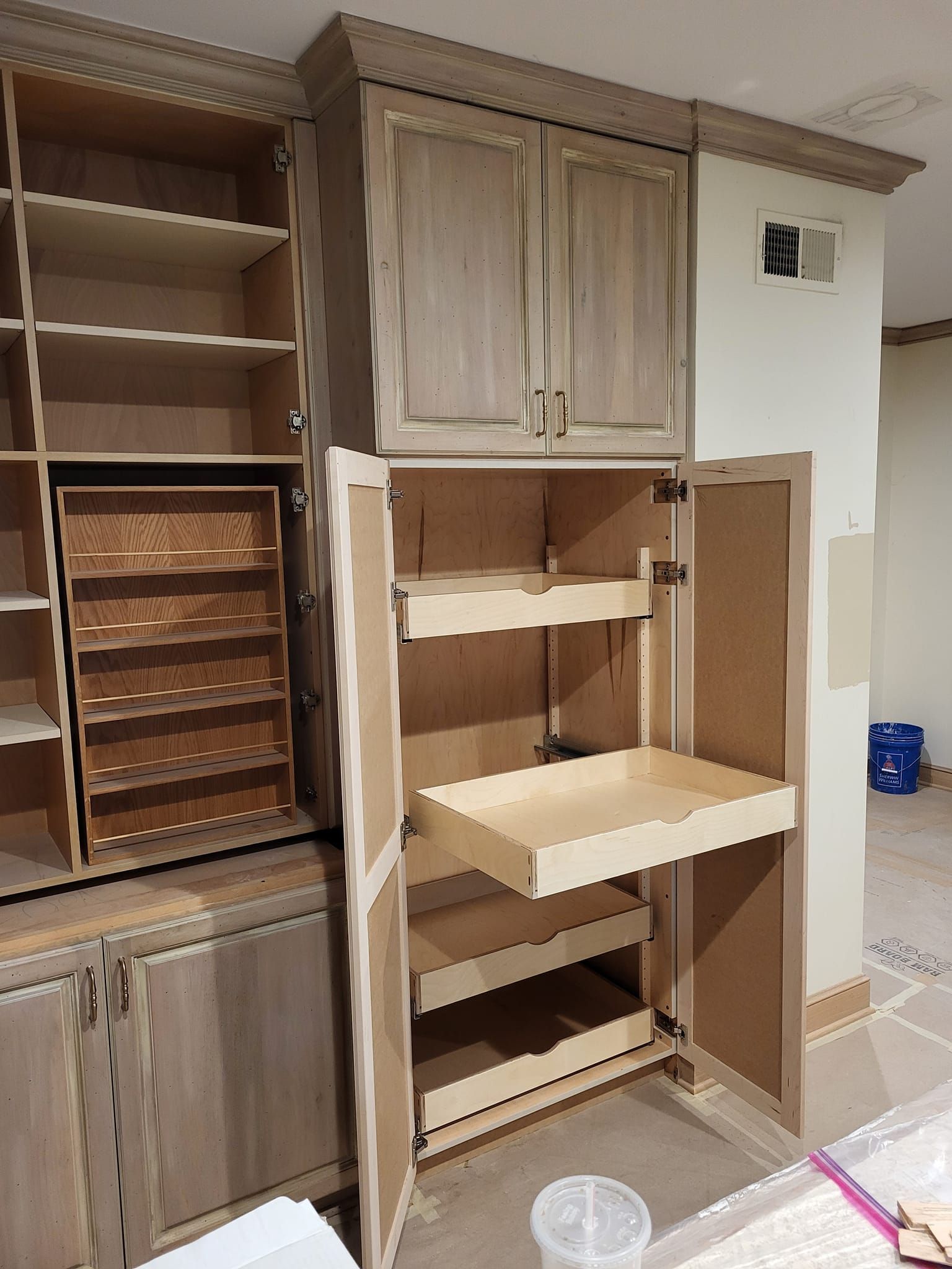 A kitchen cabinet with the door open and a pull out tray.