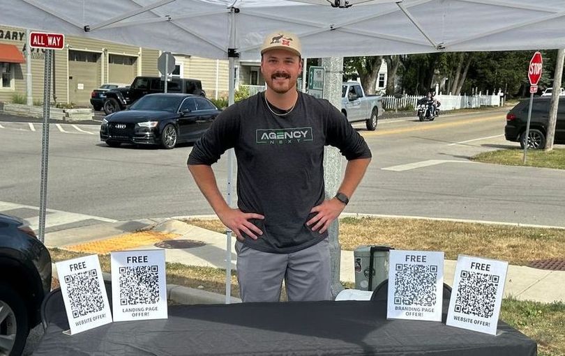 A man is standing in front of a table with qr codes on it.