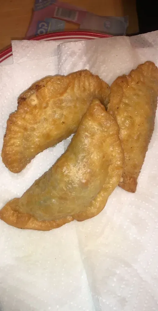 Three golden-brown, fried pastries on a white paper towel.