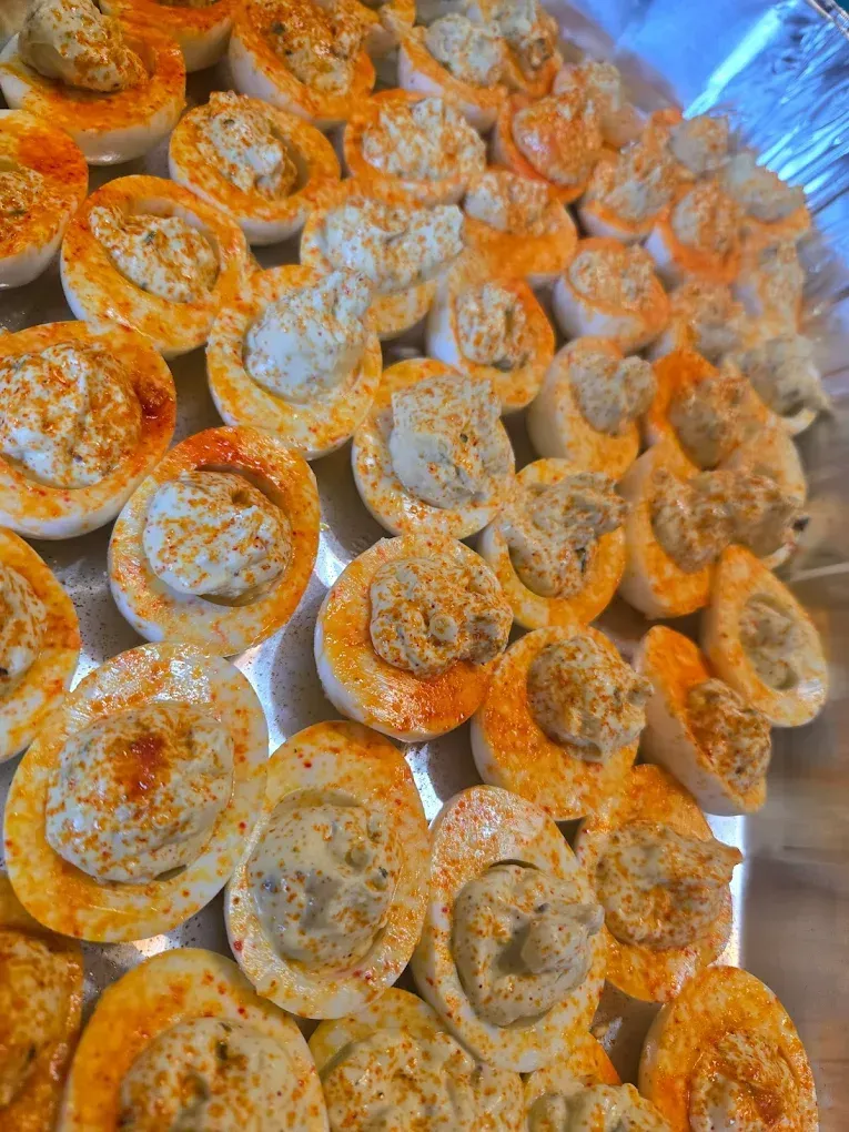 Deviled eggs in a tray, topped with paprika.
