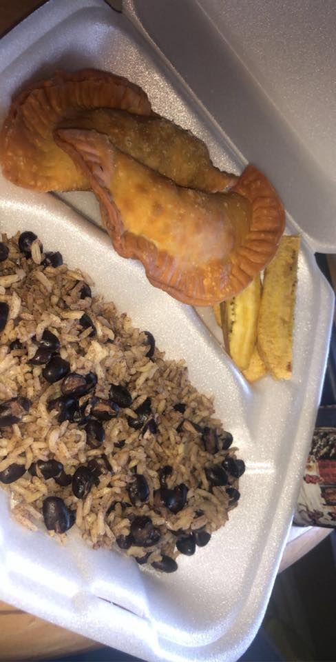 Plate of rice with beans, pastries, and fried plantains.