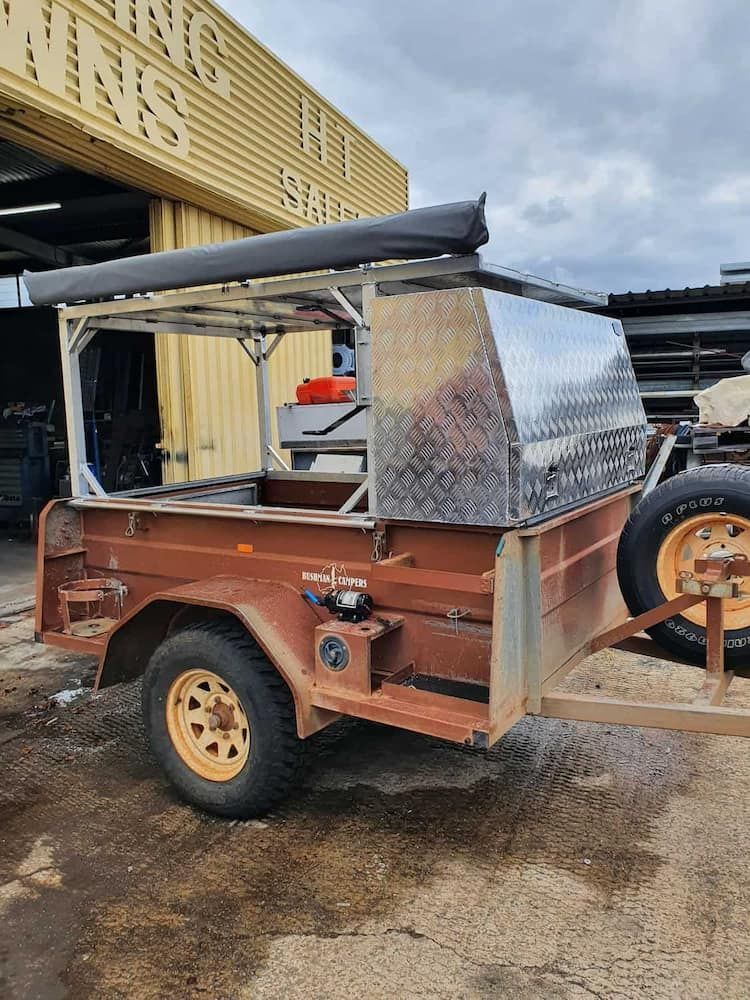 A Trailer With A Canopy Is Parked In Front Of A Building — DJ Welding & Services in Currajong, QLD