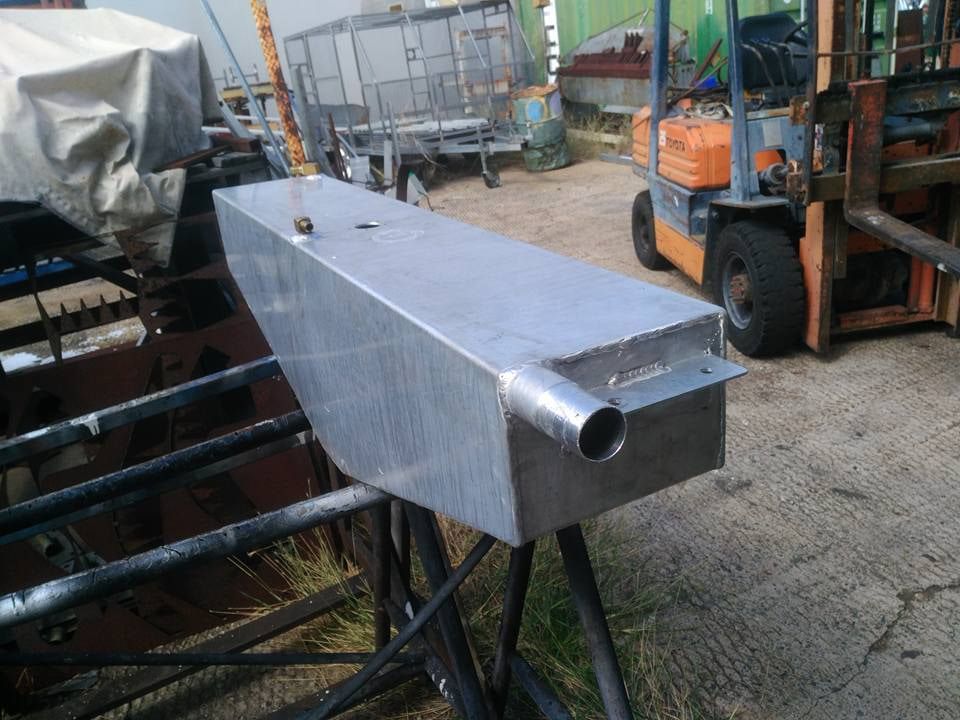 A Large Aluminum Tank Is Sitting On A Table Next To A Forklift — DJ Welding & Services in Currajong, QLD