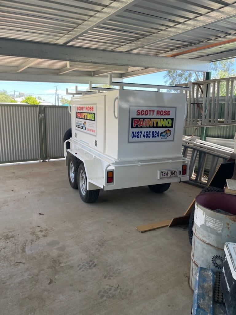 A White Trailer Is Parked Under A Roof In A Parking Lot — DJ Welding & Services in Currajong, QLD