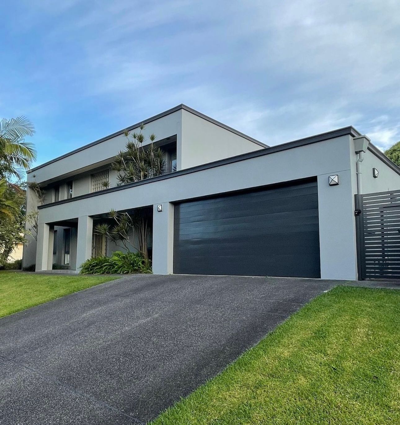 A large house with a black garage door and a driveway — Blake Saunders Painting In Edgeworth, NSW
