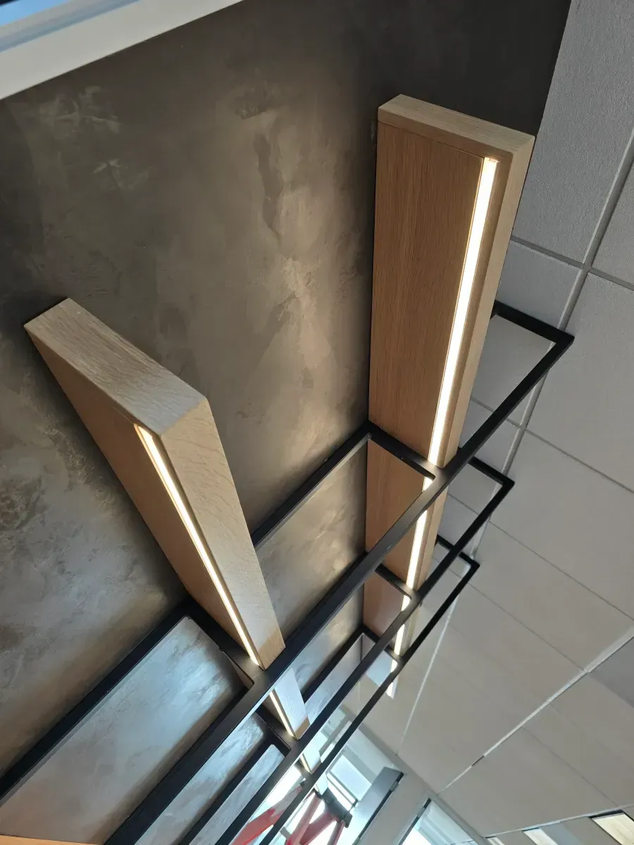 Woman in straw hat smiles, holding wine glass near a lake.