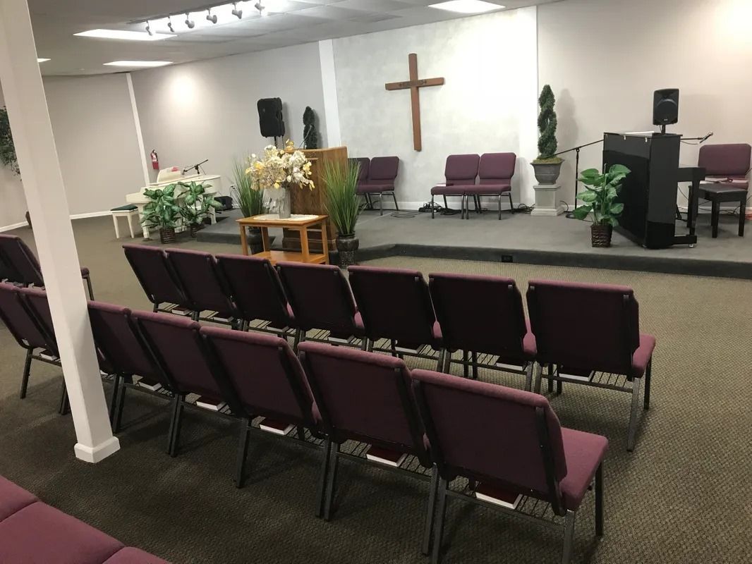 A church with purple chairs and a cross on the wall
