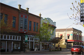 A red car is parked in front of a store called san medical