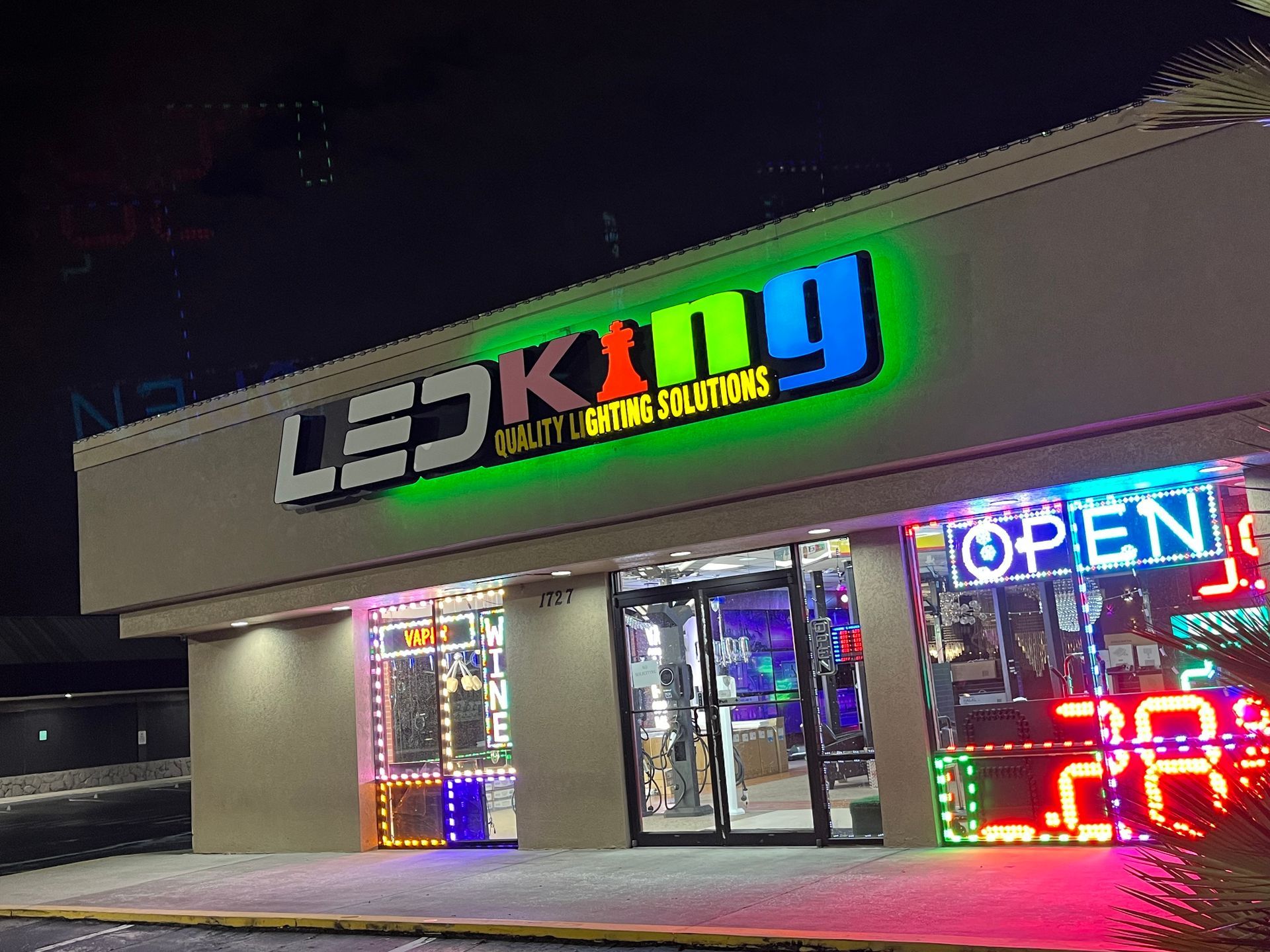 LED King store at night, lit sign with green halo, displaying lighting solutions.