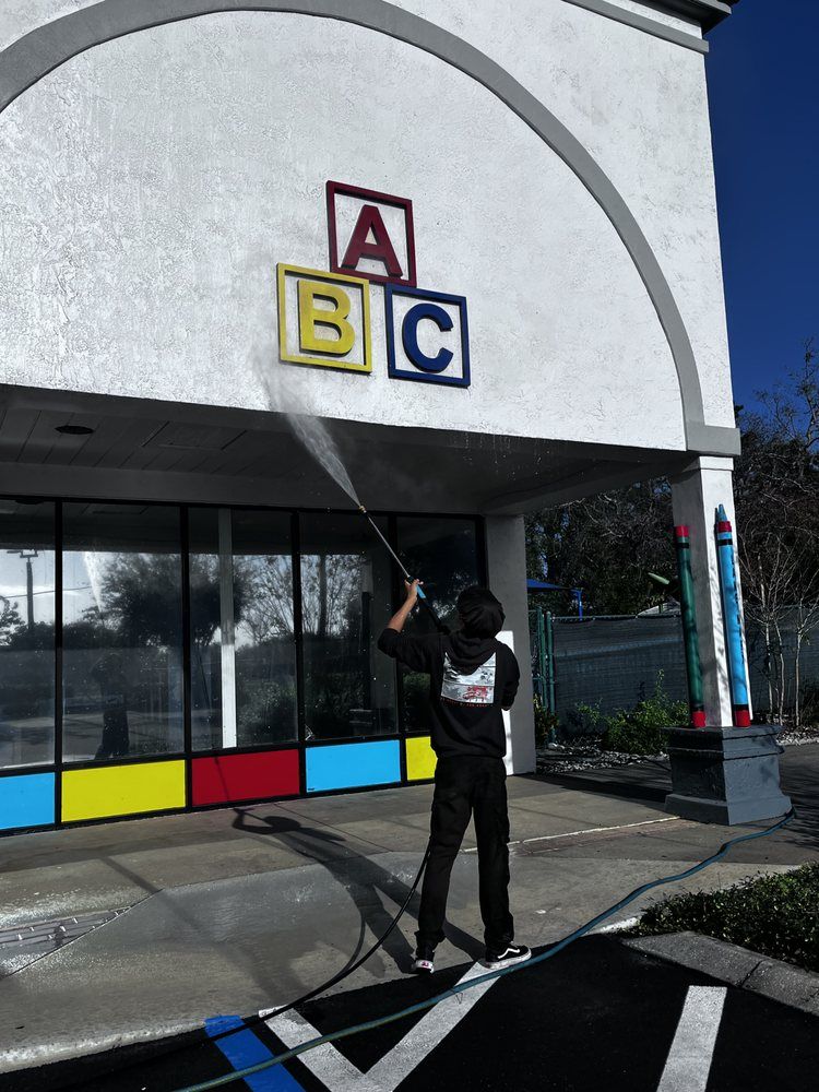 Person power washing a building with 