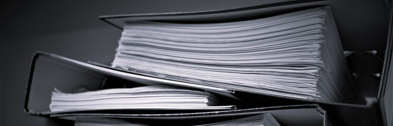 A black and white photo of a stack of papers in a binder.