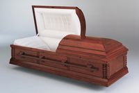 a wooden casket with the lid open is sitting on a table .