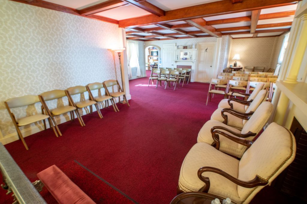 a row of chairs are lined up in a room with a red carpet .