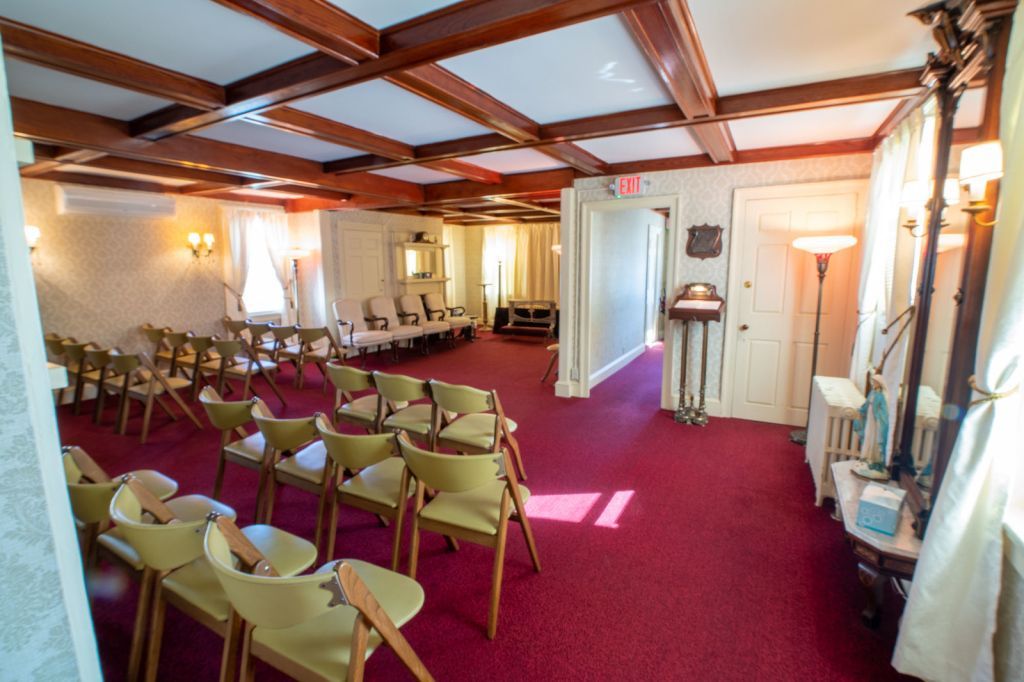 a room with rows of chairs and a red carpet