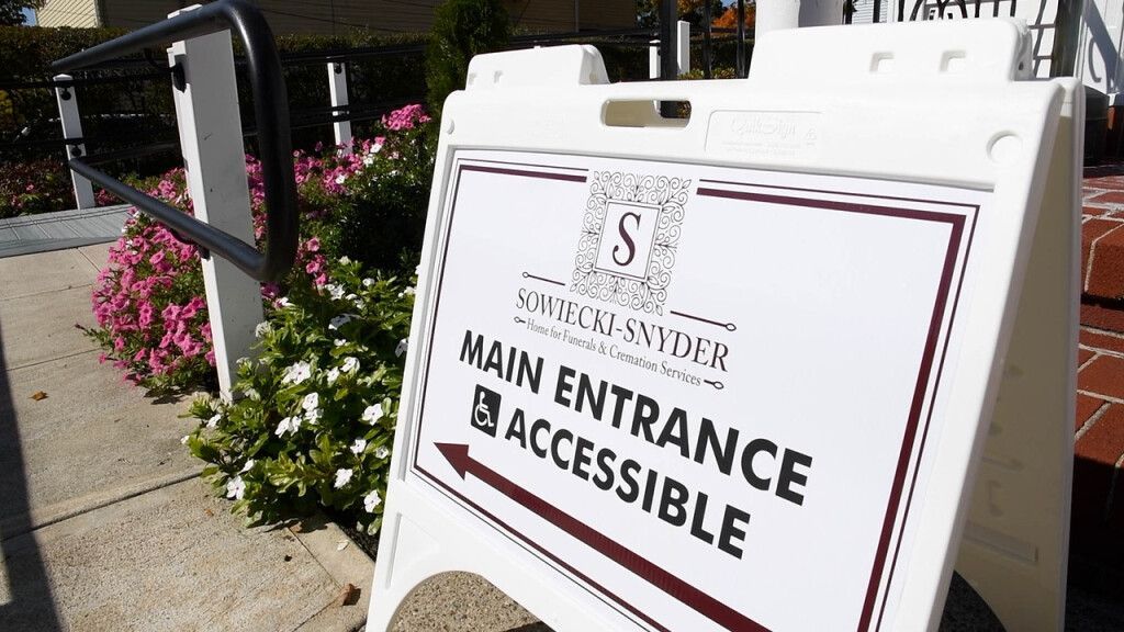 a white sign that says main entrance is accessible