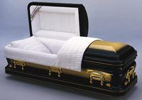 a black and gold coffin with the lid open is sitting on a table .