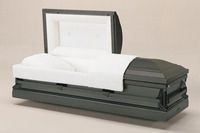 a silver coffin with the lid open is sitting on a table .