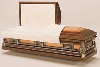 a wooden coffin with the lid open and a white blanket on it .
