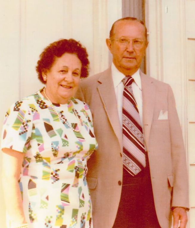 a man and woman standing in front of a funeral home