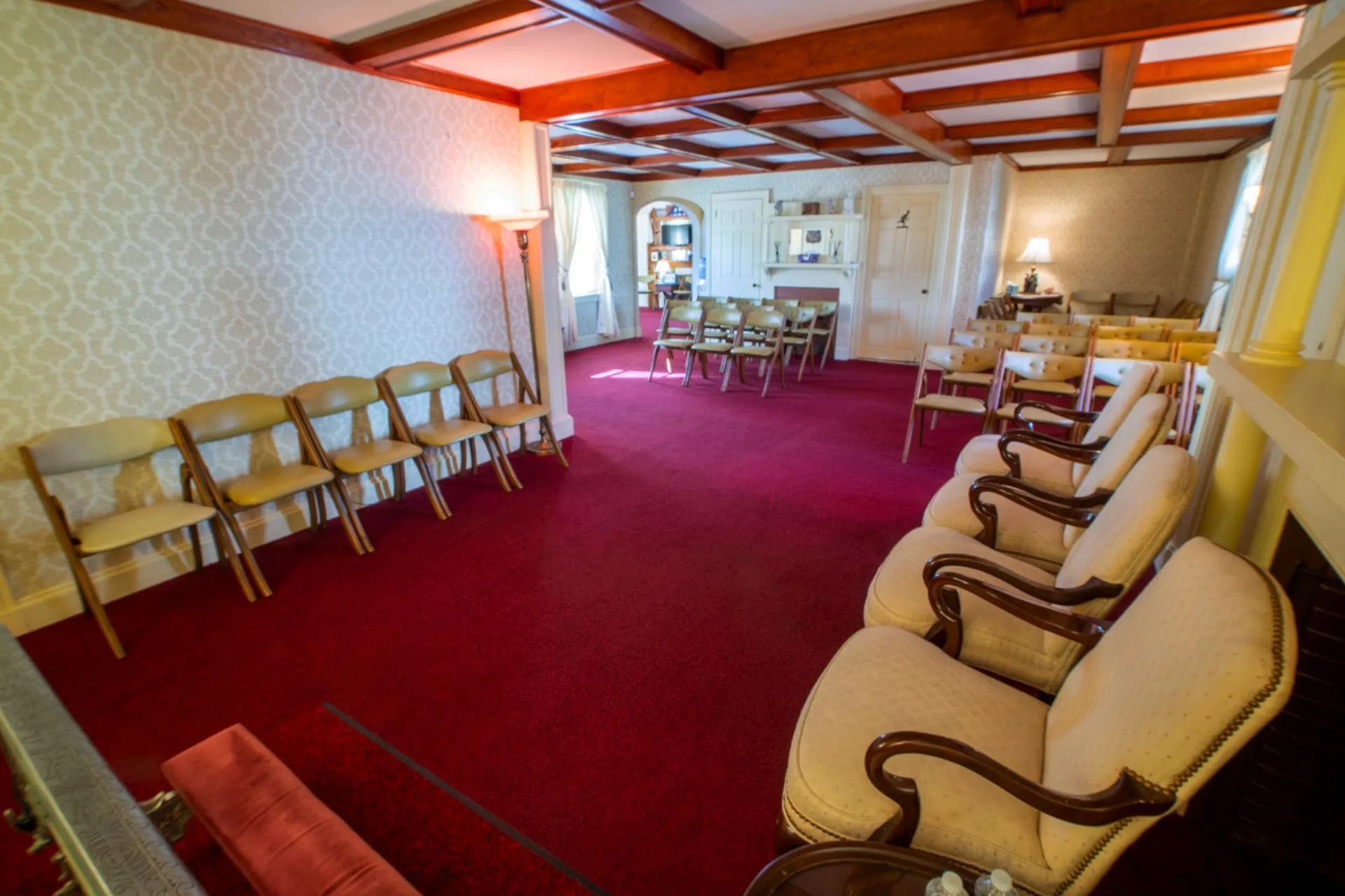 a row of chairs are lined up in a room with a red carpet .