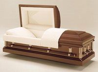 a metal casket with the lid open and a white blanket on it .