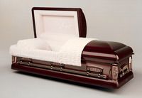 a tan brown coffin with the lid open is sitting on a white surface .