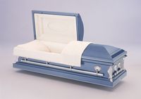 a blue casket with the lid open is sitting on a table .