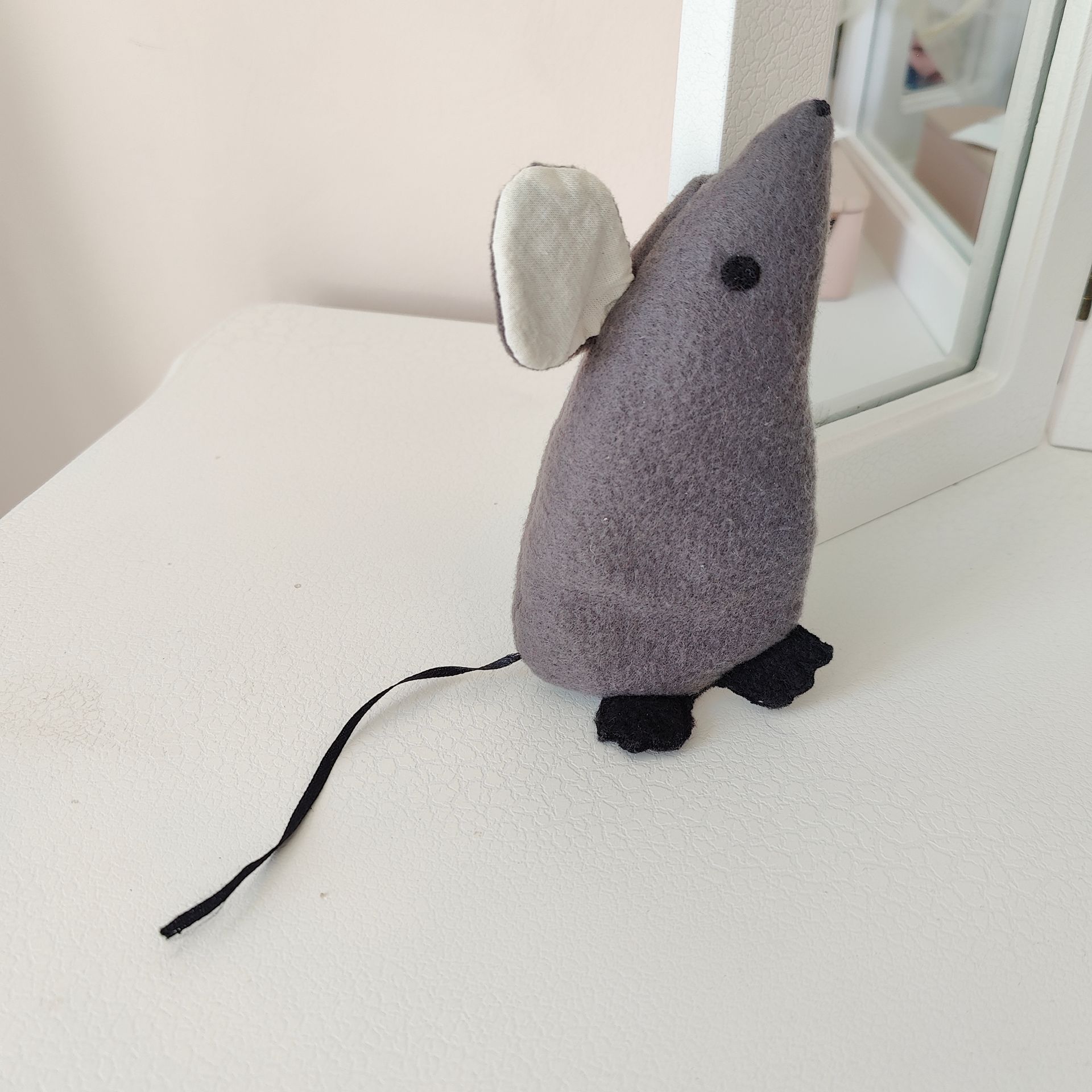 grey felt mouse near a mirror