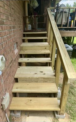 A set of wooden stairs leading up to a deck.