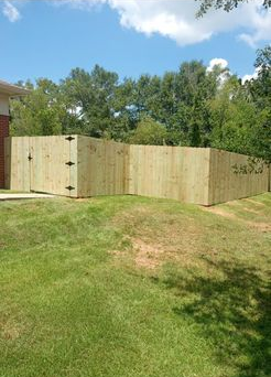 A wooden fence is sitting in the middle of a lush green field.