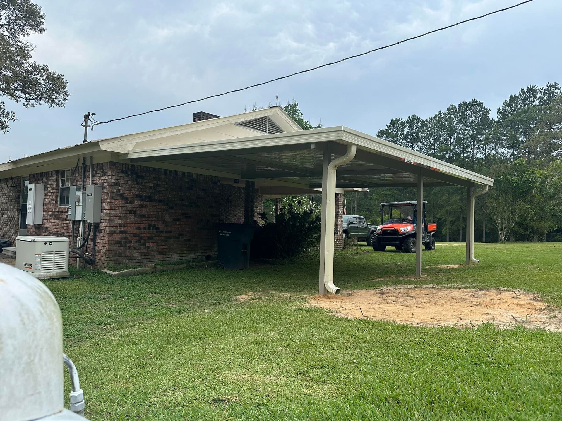 A brick house with a carport and a golf cart parked underneath it.