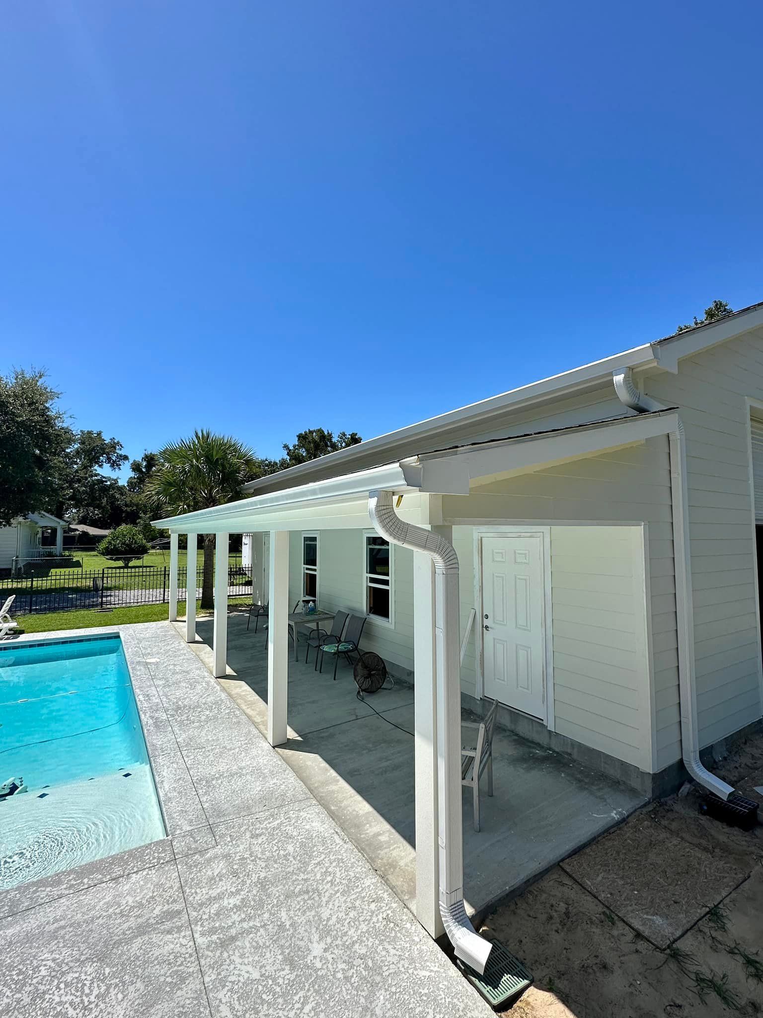 A white house with a swimming pool in the backyard.