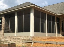 A house with a screened in porch and a lot of windows.