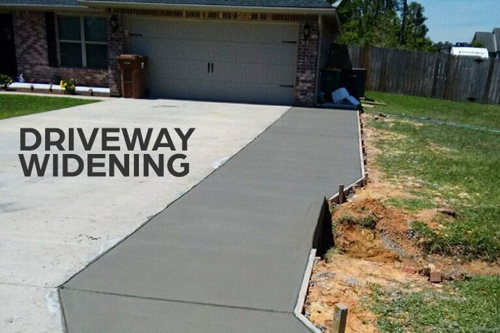 A driveway is being widened in front of a house