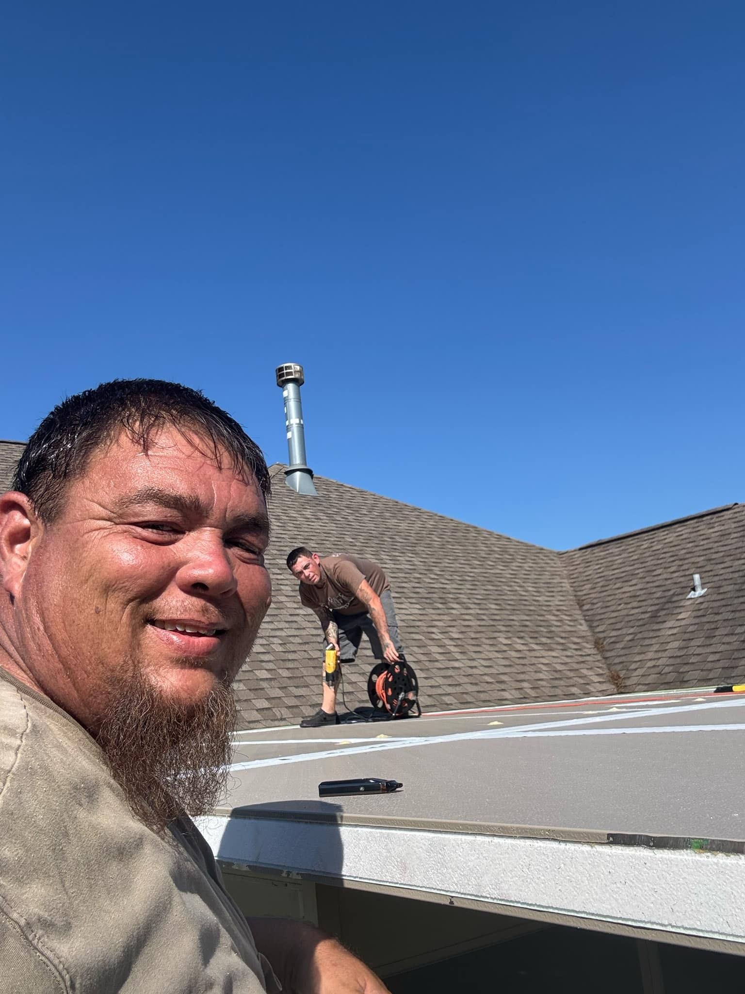 A man with a beard is standing on top of a roof.