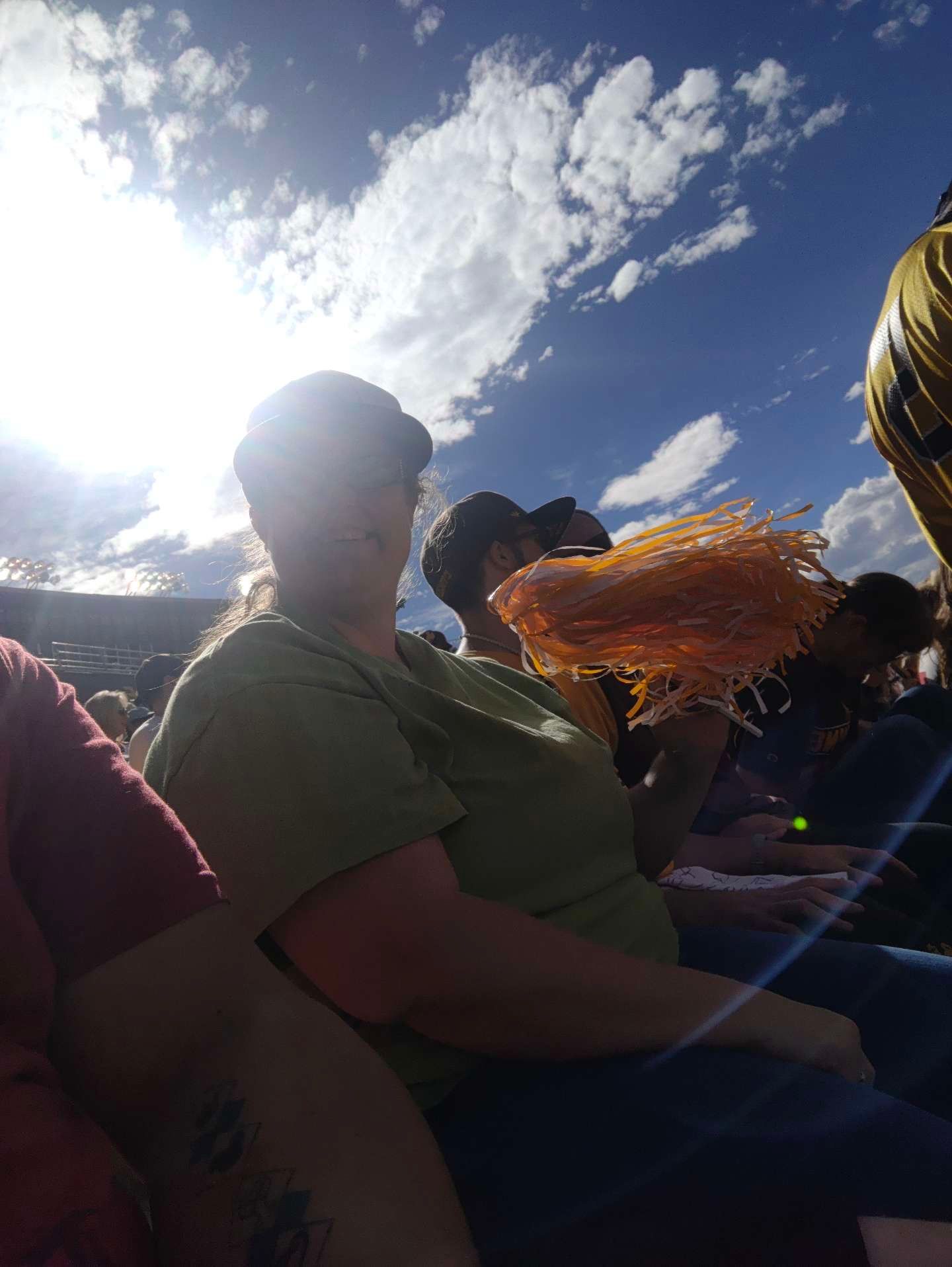 A Woman Sitting in a Stadium Holding an Orange Pom Pom — Cheyenne, WY — Treasure Abilities
