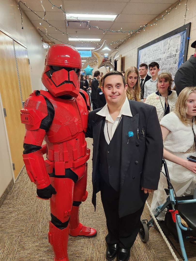 A Man in a Suit Stands Next to a Man with Red Soldier Costume — Cheyenne, WY — Treasure Abilities
