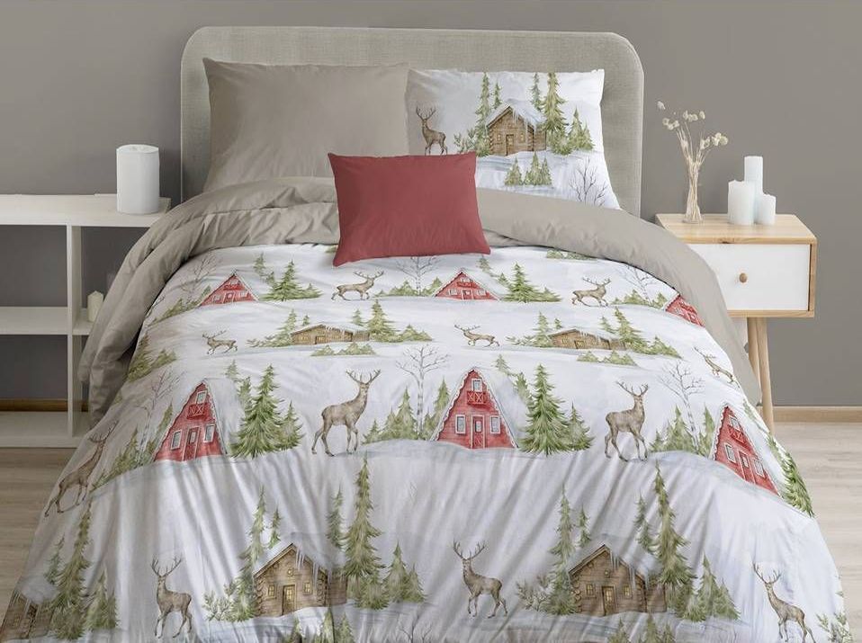 Un letto con piumone e cuscini.