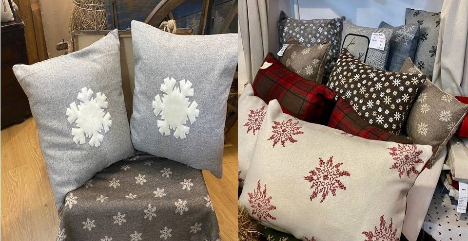 Due cuscini con sopra dei fiocchi di neve sono appoggiati su una sedia.